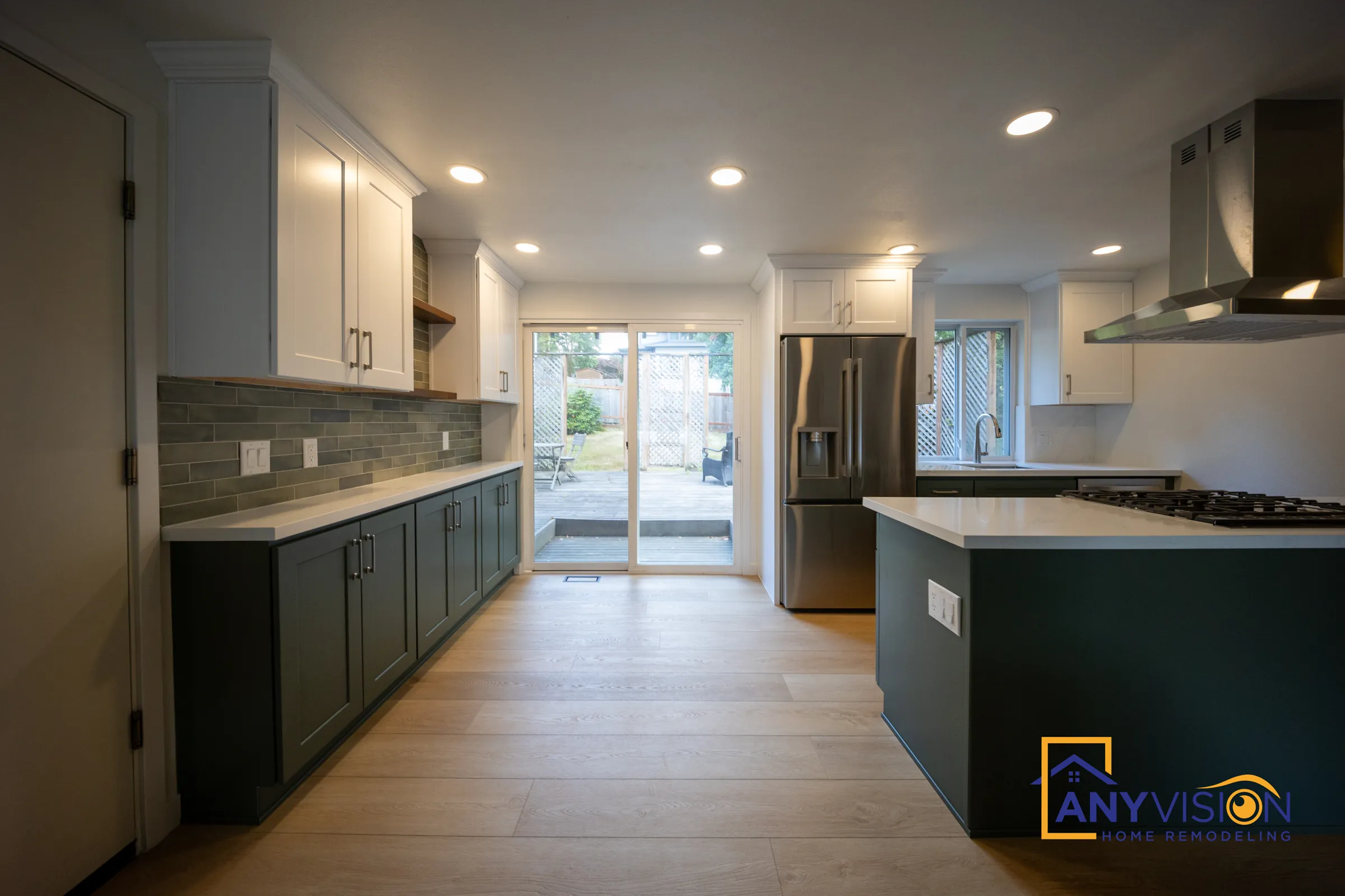Full kitchen view with green perimeter cabinets, tile backsplash and island