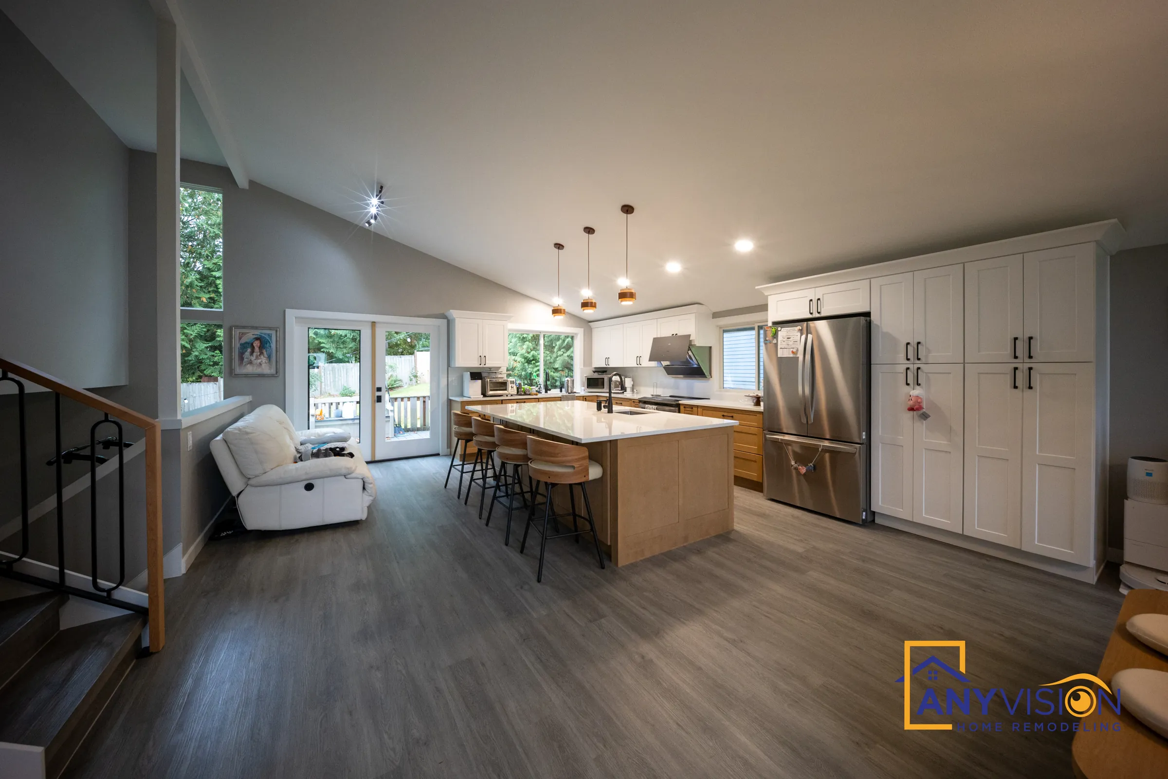Open-plan kitchen under a vaulted ceiling with a long island and French doors to the garden