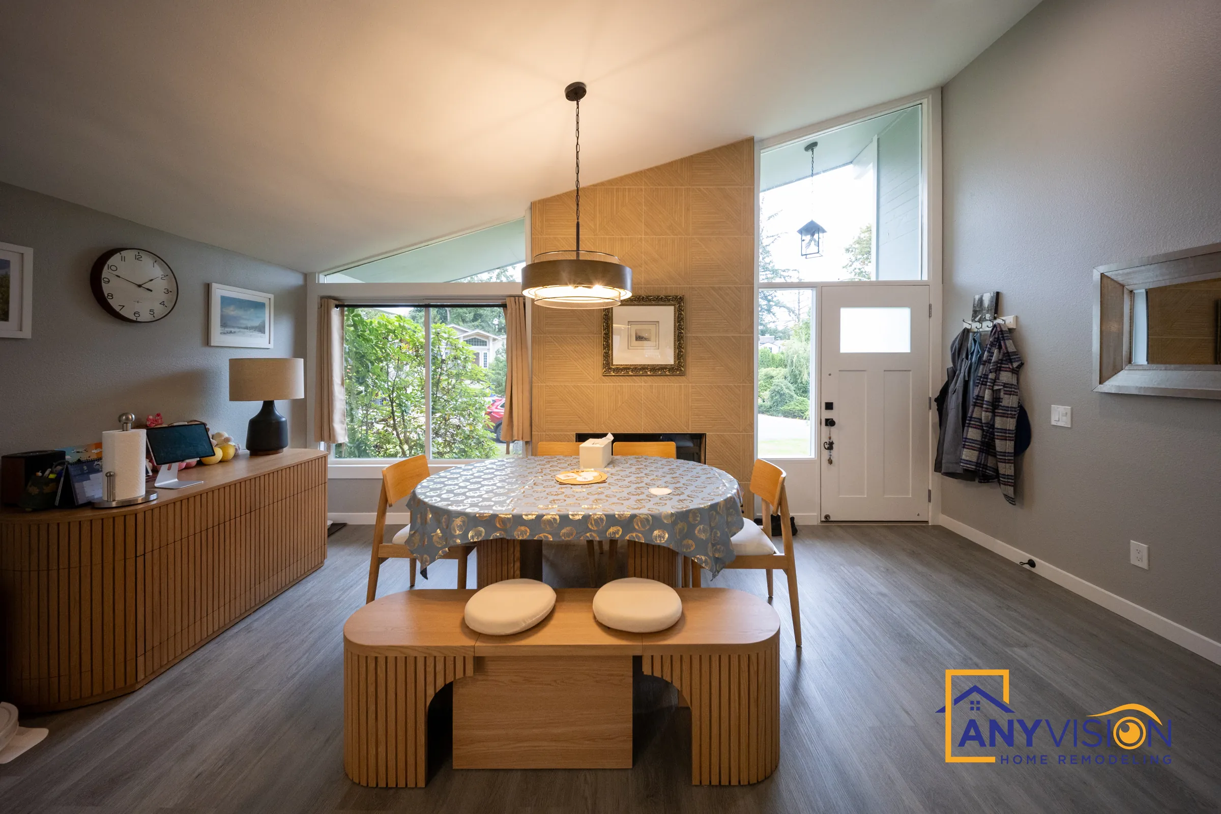 Dining area with a geometric wood accent wall, round table and fluted bench