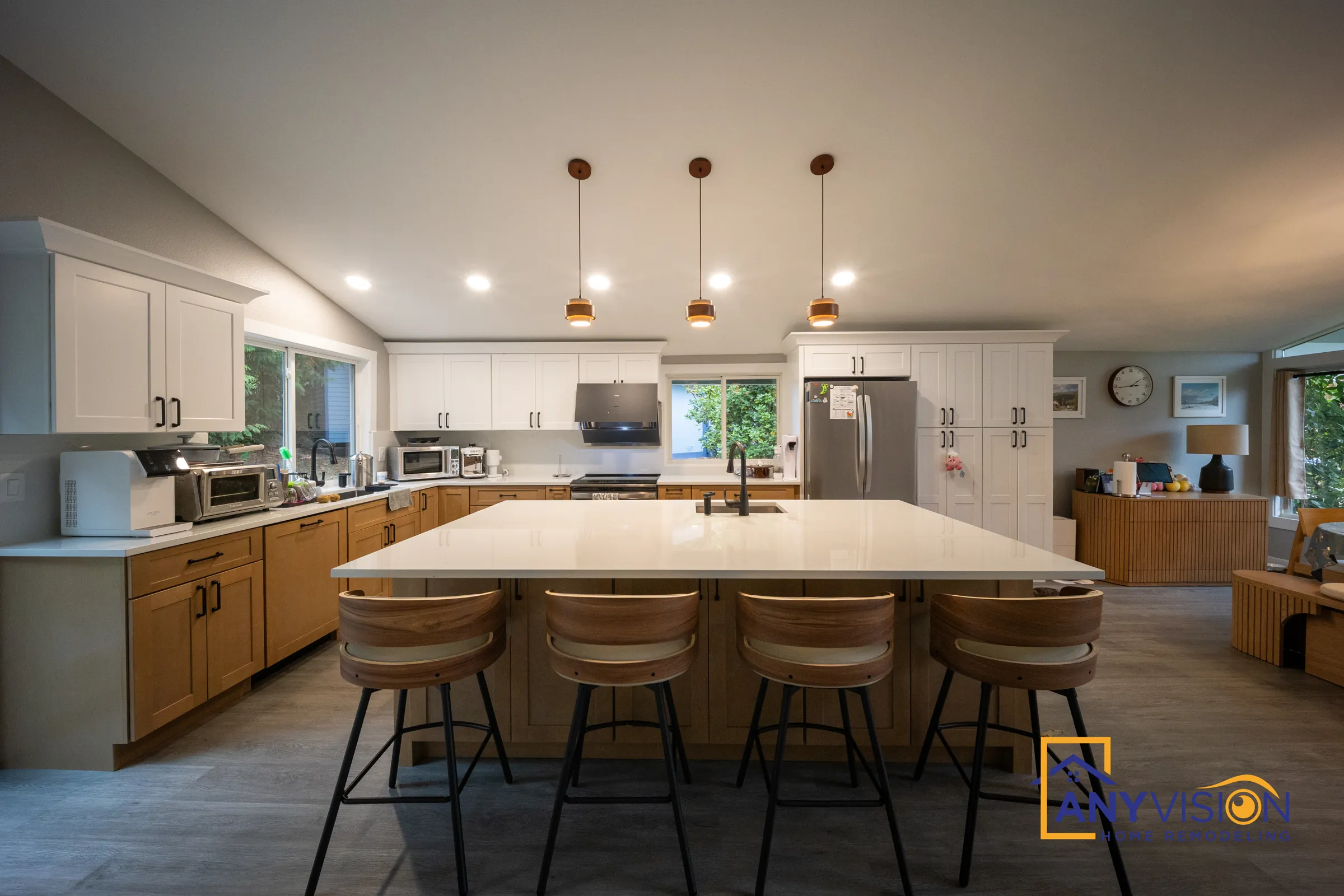 Remodeled open-plan kitchen with a long island and copper pendants in Redmond, built by Anyvision
