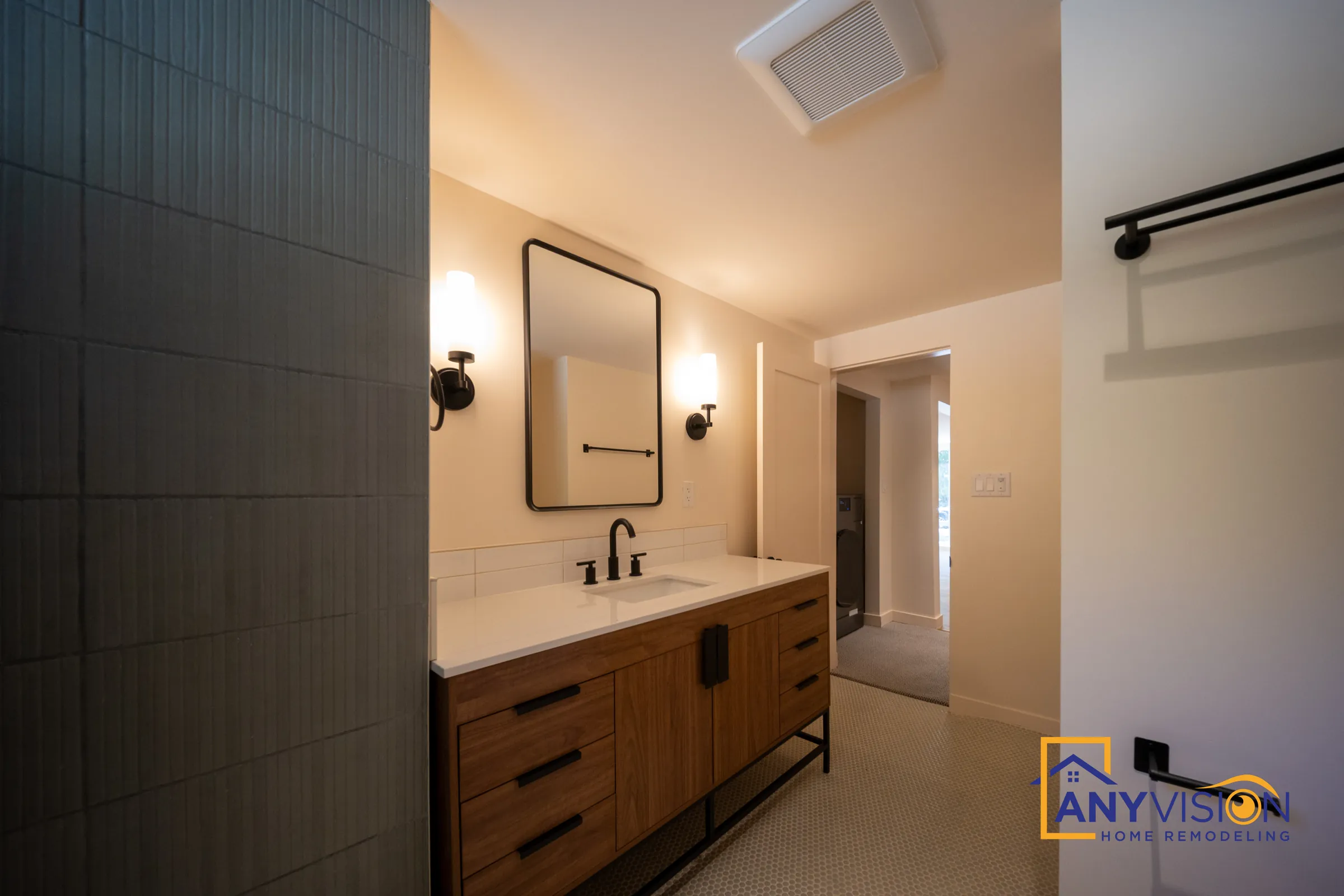 Bathroom with walnut-tone vanity, black framed mirror and green tile wall