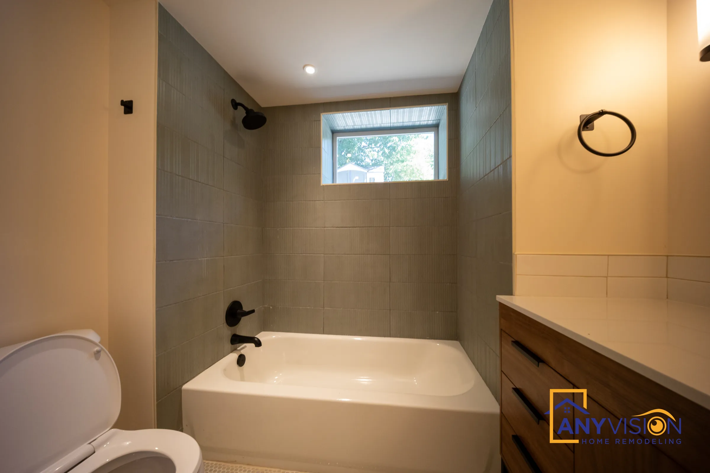 Bathtub, toilet and matte black hardware in the basement bathroom