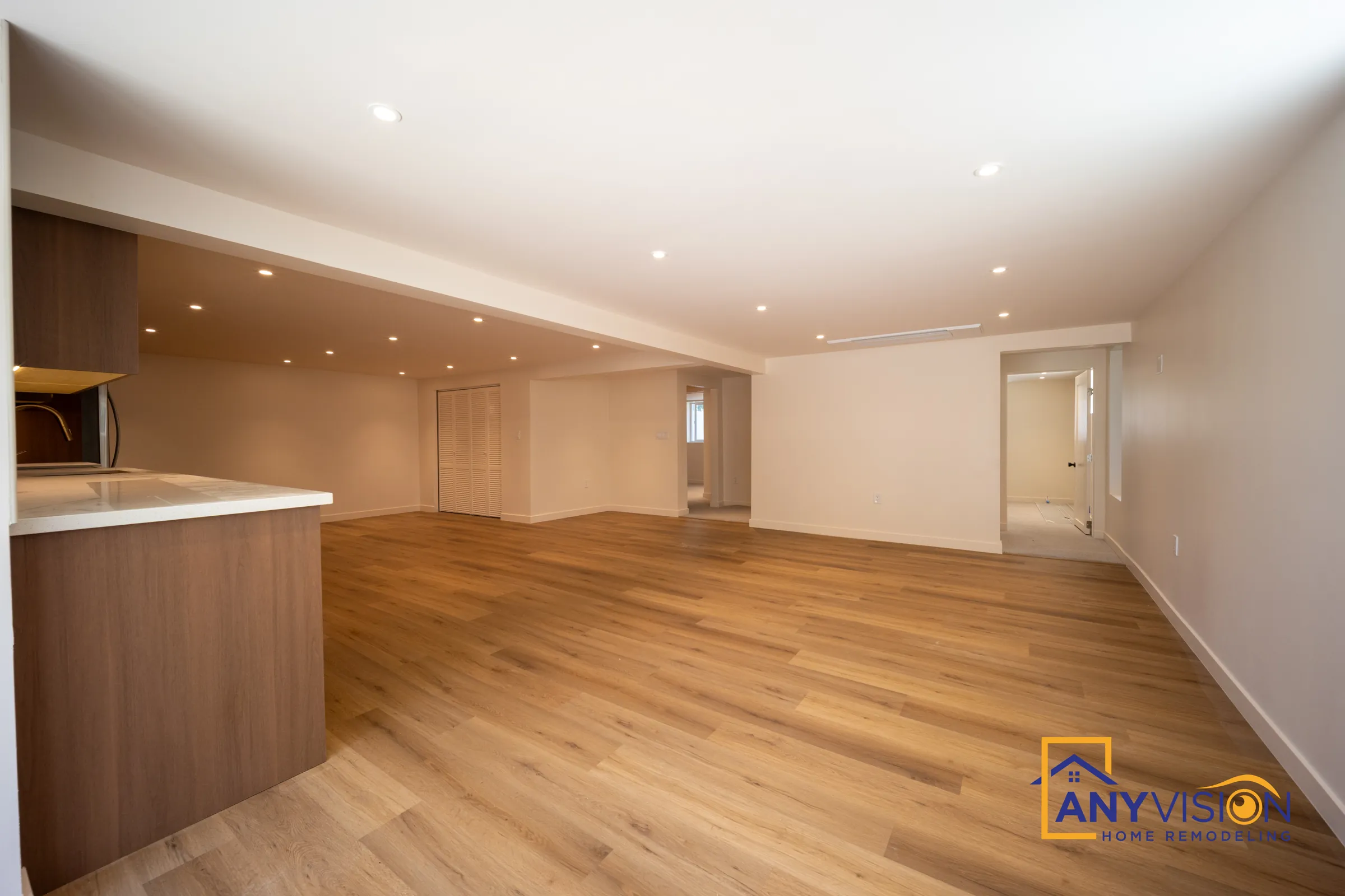 Open basement living area beside the kitchen peninsula